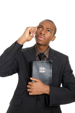 Man holding a bible whilst thinking clipart