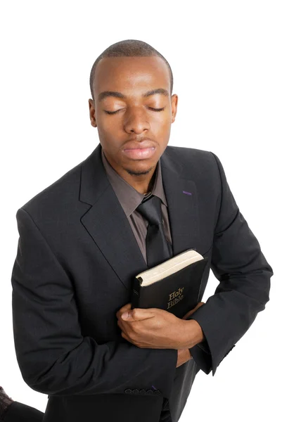 Business man on his knees holding a bible — Stock Photo, Image
