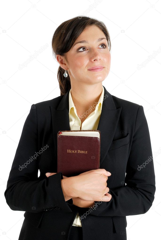 Young woman holding a bible whilst looking up