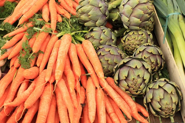 Puerros zanahorias alcachofas en primavera en un mercado —  Fotos de Stock