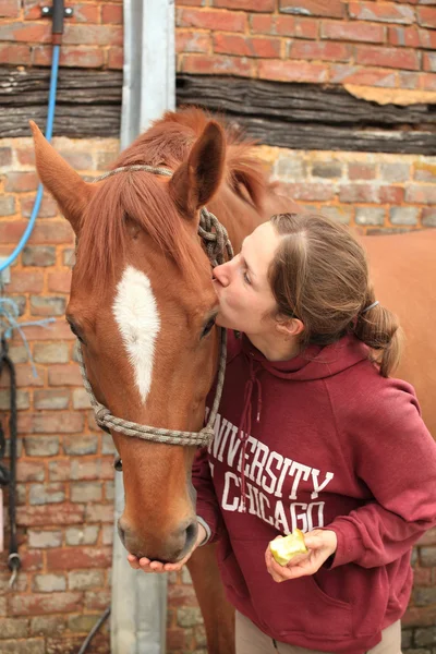 Mooie vrouwen een appel geven haar paard. — Stockfoto