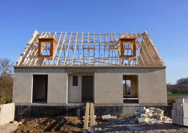 Casa em construção com a estrutura do telhado de madeira — Fotografia de Stock