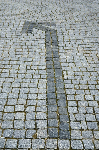 Cobbled road with arrow as background — Stock Photo, Image