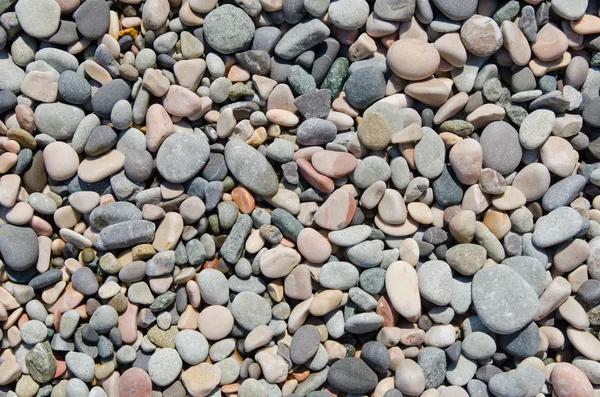 Округлые камни на пляже в качестве фона — стоковое фото