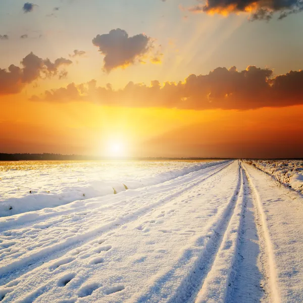 Paisagem de inverno. pôr do sol sobre a estrada com neve — Fotografia de Stock