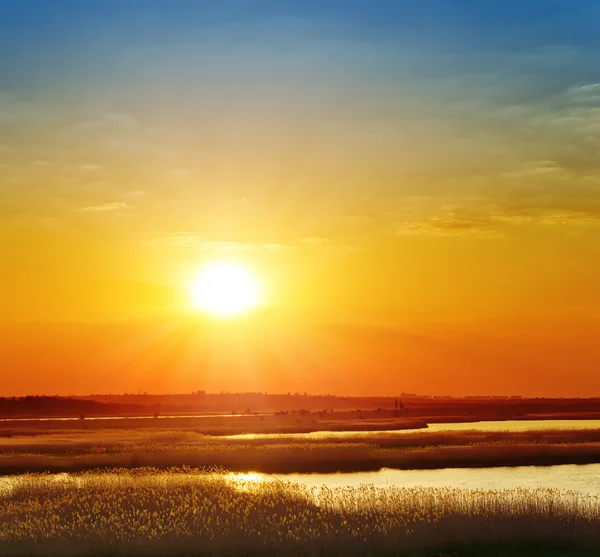 Червоний захід сонця над річкою — стокове фото