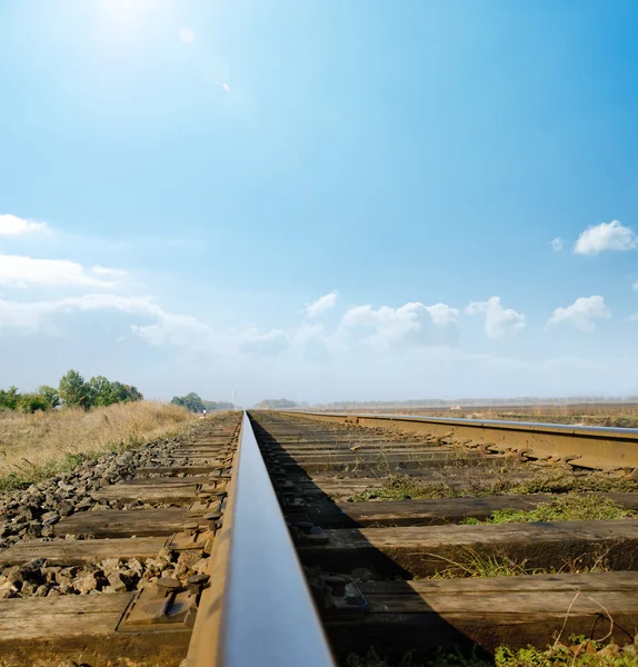 Railway to horizon under sunny sky — Stock Photo, Image