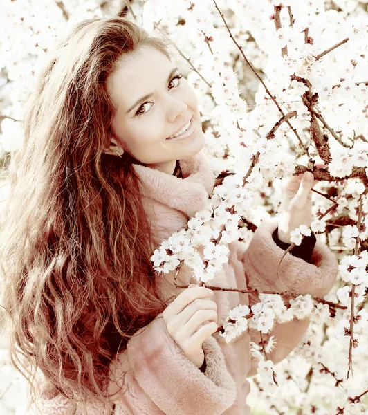 Młody atrakcyjny uśmiechający się kobieta na zewnątrz portret, kwiaty tła — Zdjęcie stockowe