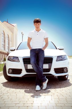 Handsome man casually leaning against the car, outdoors clipart