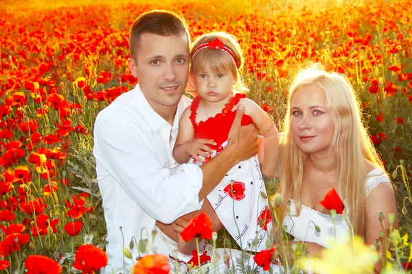 Happy family on poppies flowers field, sunset outdoors — Stock Photo, Image
