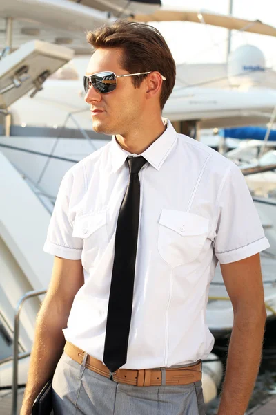 Mannen kapten i en vit skjorta nära båten, tittar bort — Stockfoto