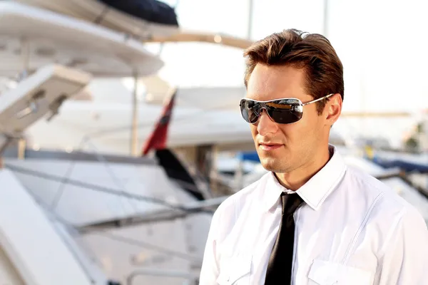Portrét příležitostné muže, sluneční brýle, přes jachta venku — Stock fotografie