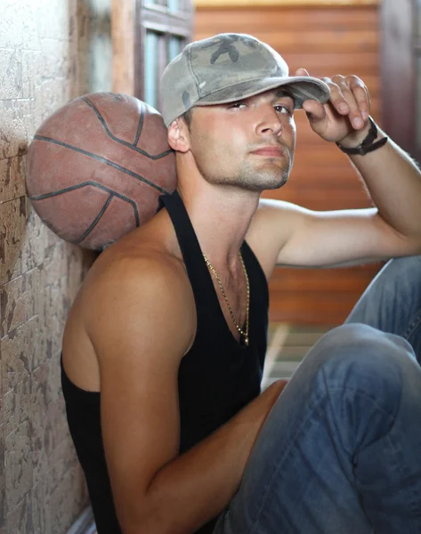 Basket spelaren rekreation, sitter på golvet — Stockfoto