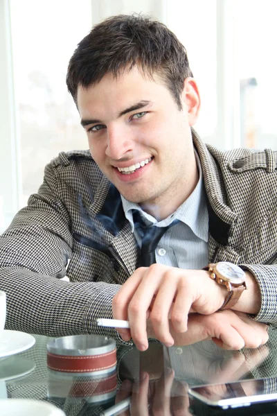 Closeup portrait of a happy young man with cigarette — Stock Photo, Image