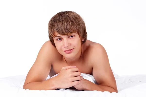 Jonge lachende gespierde mannelijk model liggend in bed — Stockfoto