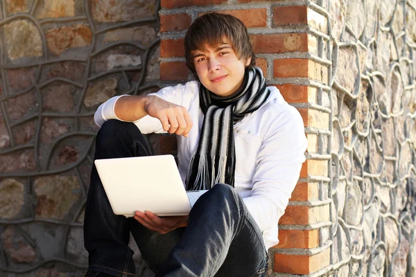 Молода людина з ноутбуком на відкритому повітрі — стокове фото