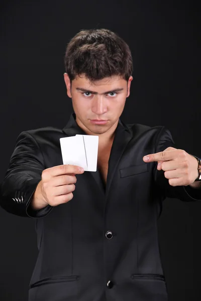 Portrait of man with blank card isolated on black background. — Stock Photo, Image