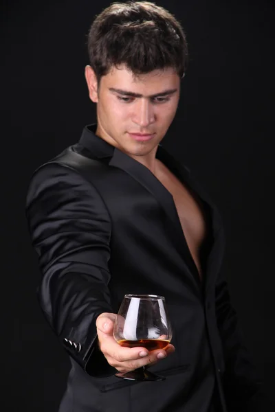 Focus op glas cognac, man op donkere achtergrond — Stockfoto