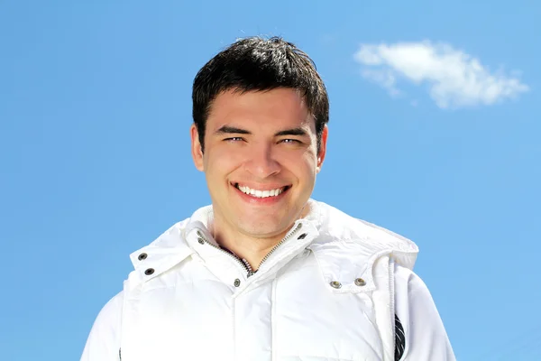 Porträtt av attraktiva lycklig man på blå himmel bakgrund utomhus — Stockfoto