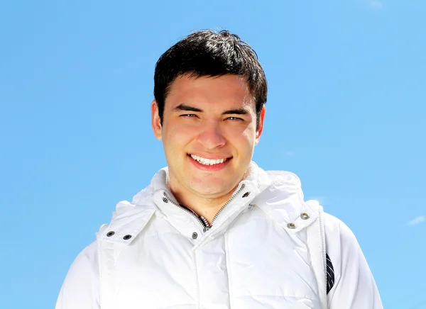 Молодой улыбающийся мужчина на открытом воздухе портрет. Мягкие солнечные цвета . — стоковое фото