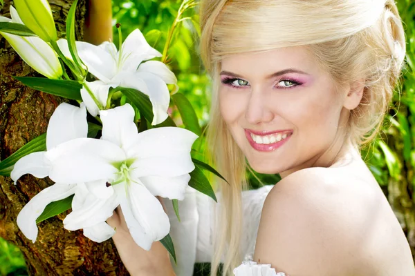Boldog, mosolygós szőke fiatal nő, fehér liliom, természet — Stock Fotó