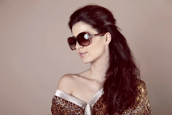 Модная женщина в солнцезащитных очках поверх бежевого — стоковое фото
