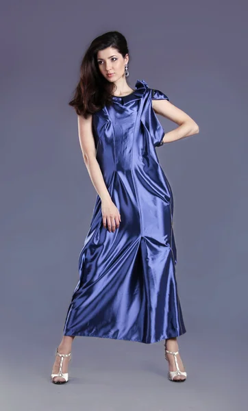 Jovem morena senhora em vestido azul posando no fundo cinza — Fotografia de Stock