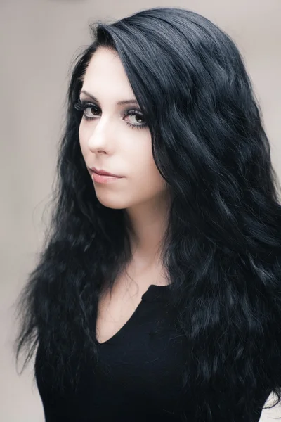 Jonge aantrekkelijk gotische brunette vrouw over grijs — Stockfoto