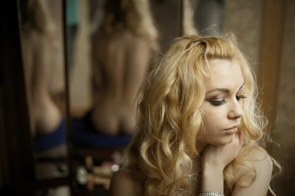 Junge Blondine über den Spiegel — Stockfoto