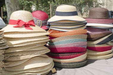 Straw hats stacked on the market clipart