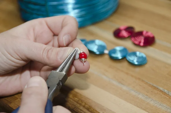 Mani di una donna che crea gioielli di moda con perle — Foto Stock