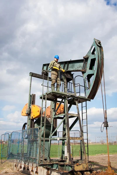 Travailleur dans l'industrie pétrolière sur pompe à huile — Photo