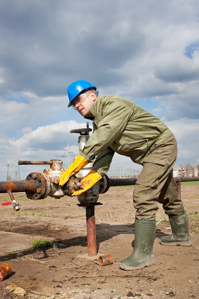 Werknemer in de olie-industrie op oliepomp — Stockfoto