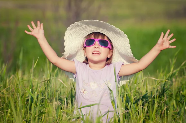 Una hermosa niña con un sombrero en un campo de grano — Foto de Stock