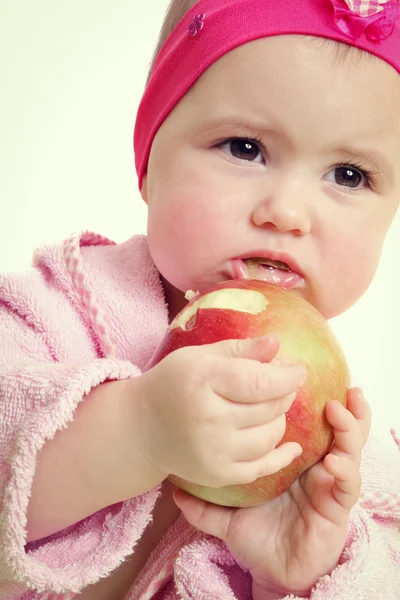 Bambino che tiene e mangia una mela, isolato su bianco — Foto Stock