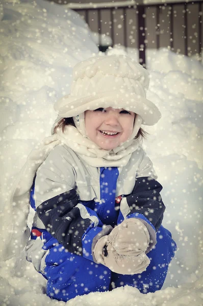 Krásná holčička s bílým kloboukem na sněhu — Stock fotografie