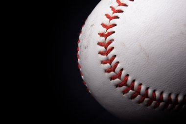 Close up of a baseball over black background clipart