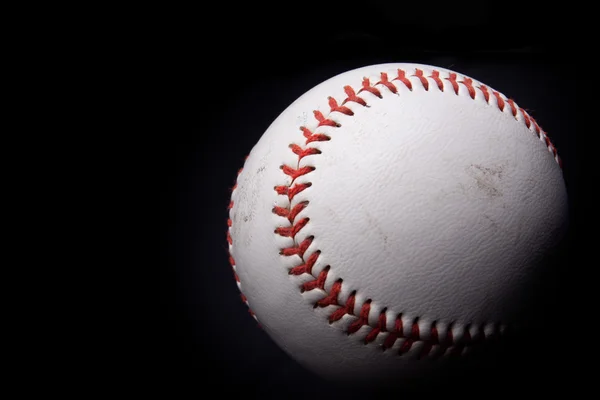 Fechar de uma bola de beisebol sobre fundo preto — Fotografia de Stock