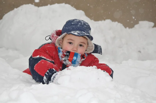 Happy little kid is playing in snow — Stock Photo, Image
