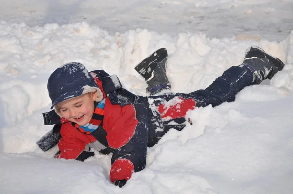Happy little kid is playing in snow — Stock Photo, Image