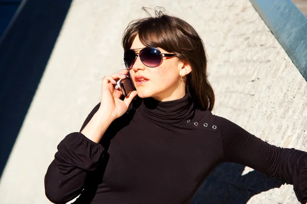 Jonge dame praten over een telefoon — Stockfoto