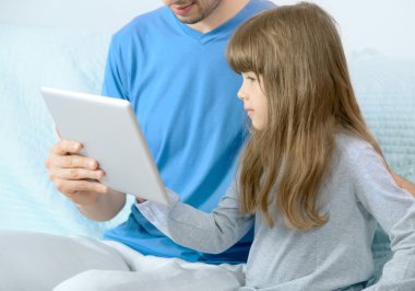 Father and daughter looking at digital tablet clipart