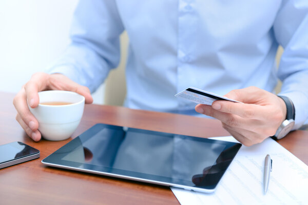 Человек, использующий кредитную карту для покупок в Интернете
