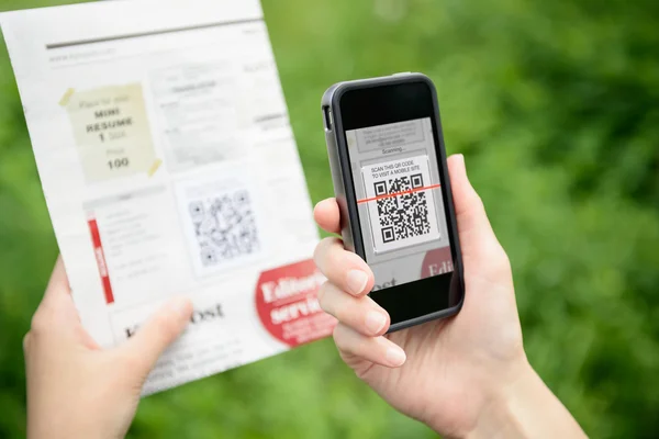 Сканирование рекламы с QR-кодом на мобильный телефон — стоковое фото