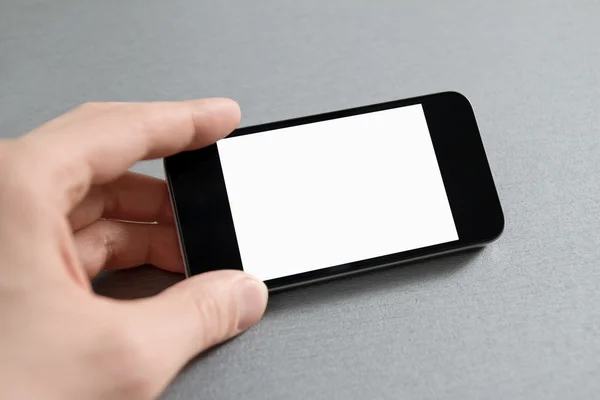 Mão mostrando telefone celular em branco — Fotografia de Stock