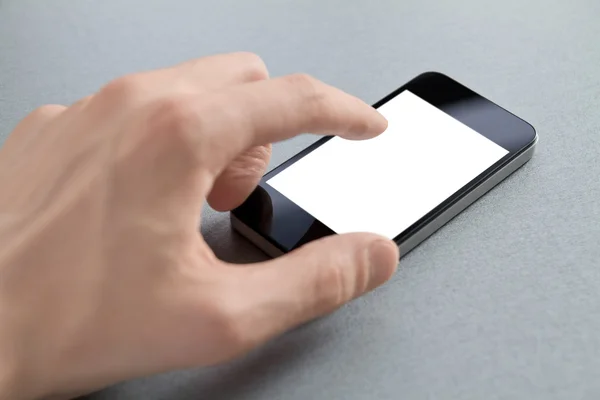 Mão tocando telefone celular em branco — Fotografia de Stock