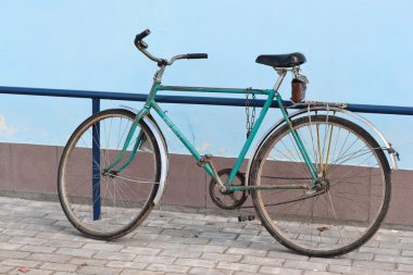 Old bike against the wall at home clipart