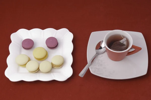 fincan çay ve gülümseme macaroons kadife örtüsü üzerinde