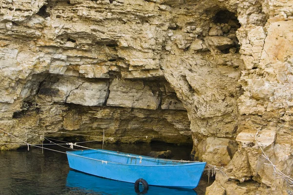 Лодка возле скалы — стоковое фото