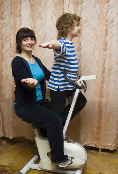 Madre e bambino su gomma bicicletta trainer — Foto Stock